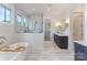 Bright bathroom boasts marble accents, a freestanding tub, and a glass-enclosed shower at 4069 Rivendell Rd, Denver, NC 28037