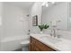 Bright bathroom featuring white tile, wood vanity, modern fixtures, and a shower-tub combo at 4069 Rivendell Rd, Denver, NC 28037