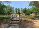 Picturesque view of a private dock on a calm lake, surrounded by lush trees, perfect for relaxation and water activities at 4069 Rivendell Rd, Denver, NC 28037