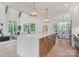 Open kitchen and living space with quartz island, stainless appliances, modern finishes and wood flooring at 4069 Rivendell Rd, Denver, NC 28037