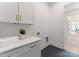 Clean laundry room with white cabinets, gold hardware, and modern appliances at 4069 Rivendell Rd, Denver, NC 28037