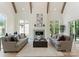 Bright living room features high ceilings, wooden beams, fireplace, and two plush sofas at 4069 Rivendell Rd, Denver, NC 28037