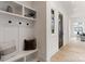 Mud room with built-in bench, shelving, and hooks for storage; wood-look flooring and white trim at 4069 Rivendell Rd, Denver, NC 28037