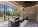 Relax on this covered patio with stylish outdoor seating and stunning waterfront and wooded views at 4069 Rivendell Rd, Denver, NC 28037