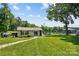 Lush backyard with a well-manicured lawn leading to the waterfront, showcasing a charming cottage and dock at 4485 River Oaks Rd, Lake Wylie, SC 29710
