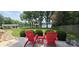 Relaxing patio with Adirondack chairs overlooking lush lawn and lake, perfect for enjoying outdoor serenity at 4485 River Oaks Rd, Lake Wylie, SC 29710