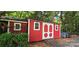 Exterior view of a painted shed with a ramp nestled in a lush, wooded backyard at 4485 River Oaks Rd, Lake Wylie, SC 29710
