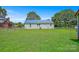 Expansive backyard featuring a well-maintained lawn, a home with a blue metal roof, and chain link fence at 4555 Us 601 Hwy, Salisbury, NC 28147