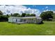 Backyard featuring green grass and a fenced-in area with a deck, perfect for outdoor entertaining and relaxation at 50 Isenhour Park Rd, Taylorsville, NC 28681