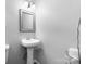 Well-lit half bathroom featuring a white pedestal sink, mirror, and essential fixtures at 50 Isenhour Park Rd, Taylorsville, NC 28681