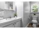 Bathroom with white tiled walls, white vanity, and a window providing natural light at 50 Isenhour Park Rd, Taylorsville, NC 28681