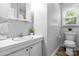Bathroom with white tiled walls, white vanity, and a window providing natural light at 50 Isenhour Park Rd, Taylorsville, NC 28681