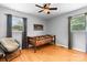 Cozy bedroom with wood floors, featuring a single bed, a comfortable chair, and natural light from two windows at 50 Isenhour Park Rd, Taylorsville, NC 28681