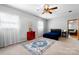 Bright, carpeted bedroom showcasing a comfortable bed, two windows, and a unique red accent cabinet at 50 Isenhour Park Rd, Taylorsville, NC 28681