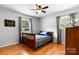 Cozy bedroom features hardwood floors, a ceiling fan, and natural light from two windows at 50 Isenhour Park Rd, Taylorsville, NC 28681