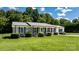 Inviting single-story brick home with a lush green lawn and a charming front porch at 50 Isenhour Park Rd, Taylorsville, NC 28681