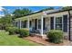 Inviting front porch with chairs, brick detailing, and well-manicured shrubbery at 50 Isenhour Park Rd, Taylorsville, NC 28681