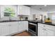 Updated kitchen showcasing stainless steel oven, white cabinets, granite countertops, and natural light at 50 Isenhour Park Rd, Taylorsville, NC 28681
