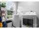 Functional laundry room featuring a washer, dryer, shelving, and a window for natural light at 50 Isenhour Park Rd, Taylorsville, NC 28681