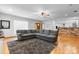 Open-concept living room with a large sectional couch, wood floors, and a brick accent wall in the kitchen at 50 Isenhour Park Rd, Taylorsville, NC 28681