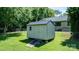 A small shed with a ramp is surrounded by green grass and trees in a well-kept backyard at 50 Isenhour Park Rd, Taylorsville, NC 28681