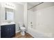 A clean bathroom features white fixtures, dark blue vanity, and wood-look floors at 5375 Eneida Sue Dr, Charlotte, NC 28214
