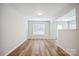 Open-concept living room with wood floors, bright walls, and large window at 5375 Eneida Sue Dr, Charlotte, NC 28214