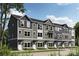 Townhome showcasing a gray and white exterior, multiple windows, and manicured lawn at 542 Beatties Ford Rd, Charlotte, NC 28216