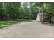 A gravel driveway leads to an outbuilding and carport with trees bordering the grass at 5890 Alley Rd, Catawba, NC 28609