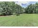 The large, green yard is surrounded by trees in a natural, peaceful setting at 5890 Alley Rd, Catawba, NC 28609