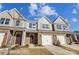 Charming townhomes with stone accents, attached garages, and well-manicured lawns offer modern living at 6274 Tea Olive Dr # 237, Harrisburg, NC 28075