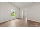 Well-lit bedroom with wood-look flooring, neutral walls, and a view of the backyard at 7106 Jerimoth Dr, Charlotte, NC 28215