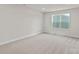 Well-lit bedroom with neutral carpet, a large window, and crisp white trim at 7314 Jerimoth Dr, Charlotte, NC 28215
