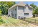 The backyard has a beautiful lawn, black fence, and a concrete patio for outdoor enjoyment at 738 Kemp Rd, Mooresville, NC 28117