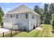 View of back exterior featuring a well maintained lawn, black fence, patio, and blue siding at 738 Kemp Rd, Mooresville, NC 28117