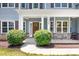 Inviting front entrance with gray siding, stone accents, and a charming covered porch at 738 Kemp Rd, Mooresville, NC 28117