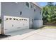 Spacious two car garage with white door and black hardware, located on the side of a beautiful blue home at 738 Kemp Rd, Mooresville, NC 28117