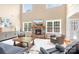 Bright living room features fireplace, large windows, wood flooring, and comfortable seating arrangement at 738 Kemp Rd, Mooresville, NC 28117