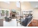 Inviting living room with stone fireplace, large windows, hardwood floors, and access to the modern kitchen at 738 Kemp Rd, Mooresville, NC 28117