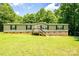 Single-story home with front-facing porch and yard, framed by mature trees on a sunny day at 812 Acclaim Dr, York, SC 29745