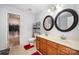 A bathroom featuring double sinks, cabinet storage, a walk-in closet and two circular mirrors at 9822 Bayview Pkwy, Charlotte, NC 28216
