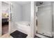 Bathroom featuring corner soaking tub and separate glass enclosed shower at 9822 Bayview Pkwy, Charlotte, NC 28216