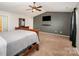 A spacious carpeted bedroom featuring a flat screen tv and an attached bathroom at 9822 Bayview Pkwy, Charlotte, NC 28216