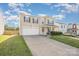 A charming two-story home featuring an attached garage and a front lawn under a partly cloudy sky at 9822 Bayview Pkwy, Charlotte, NC 28216