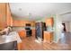 Open kitchen with wood cabinets, modern black appliances, and an adjacent dining area at 9822 Bayview Pkwy, Charlotte, NC 28216