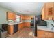 Spacious kitchen boasts ample wood cabinetry, practical layout, and modern black appliances at 9822 Bayview Pkwy, Charlotte, NC 28216
