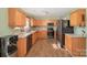 Functional kitchen with wood cabinets, modern black appliances, and plenty of counter space at 9822 Bayview Pkwy, Charlotte, NC 28216
