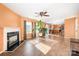 Open-concept living room with wood floors, a fireplace, ceiling fan, and a view into the kitchen at 9822 Bayview Pkwy, Charlotte, NC 28216
