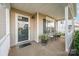 Inviting front porch with seating area, window with shutters, and a decorative potted plant at 9822 Bayview Pkwy, Charlotte, NC 28216