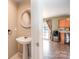Stylish powder room with pedestal sink leading into a bright kitchen at 9822 Bayview Pkwy, Charlotte, NC 28216